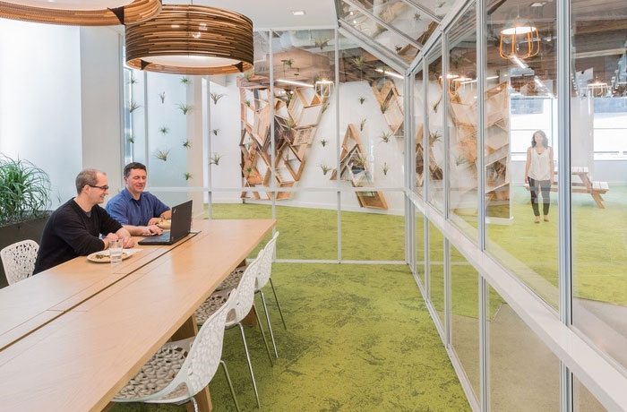 Adobe Headquarters meeting room with clear glass walls, textured grassy carpet,s and a long wooden table