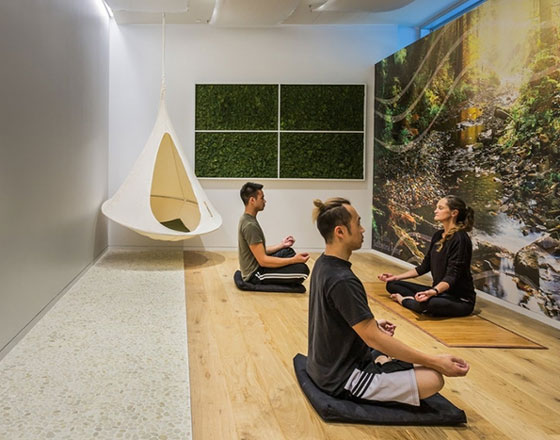 yoga room with three people and a nature mural