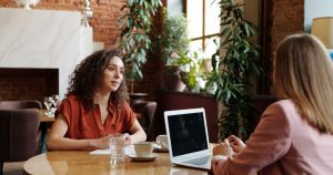 two women in a plant filled office participating in a job interview