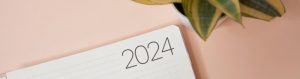 A 2024 planner with a pen sitting next to a potted plant