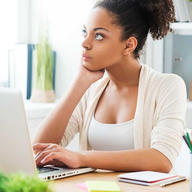 woman in front of a computer thinking about future personal and professional goals