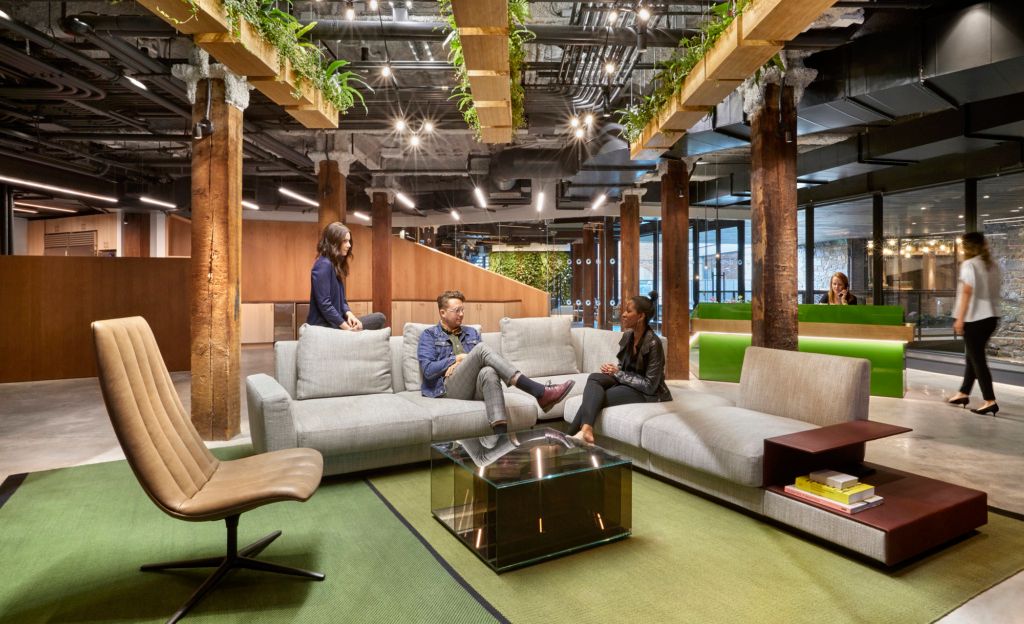 biophilic design in the united technologies workplace with neutral couches and natural wooden planters hanging from the ceiling