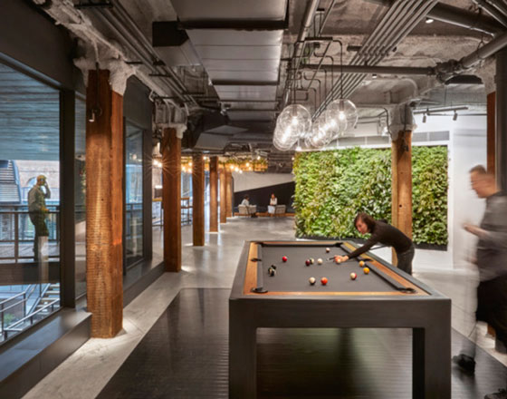 image of united technologies digital offices with a plant wall and pool table