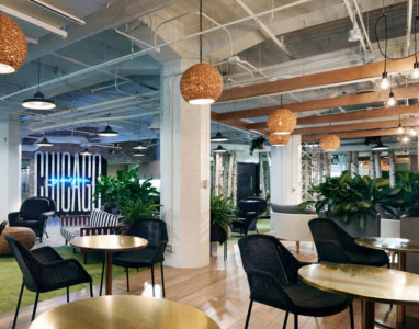 open seating area with wooden floor, small tables, and planter dividers